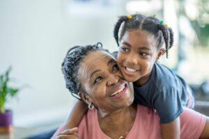 A grandchild embraces her grandparent caregiver.