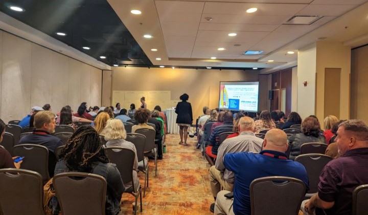 Connectedly staff and participants present at a conference.