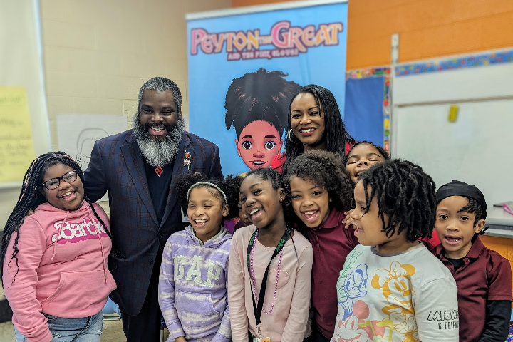 Children pose at a Philly Families Read Together event with author Terrenny Robinson and Harrington School's Principal Fulton.