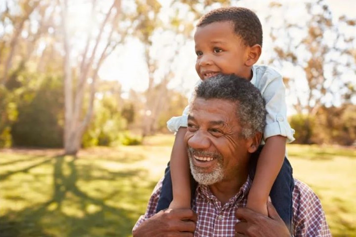 Photo of a grandparent caregiver holding his grandchild